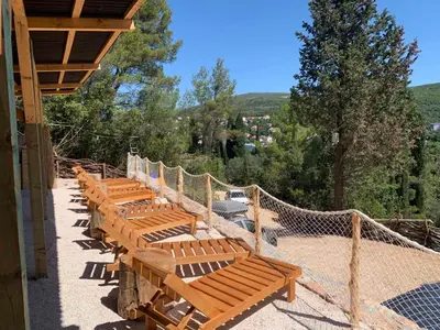 a row of wooden benches sitting on a patio at Bigova Glamping in Kotor