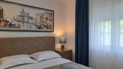 a bedroom with a bed with a picture on the wall at Villa Dedin in Utjeha