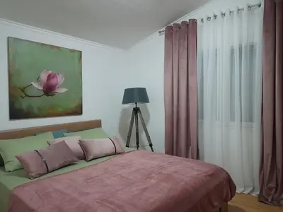 a bedroom with a bed with a pink blanket and a window at Villa Dedin in Utjeha