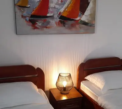 a bedroom with two beds and a lamp on a table at Villa Dedin in Utjeha
