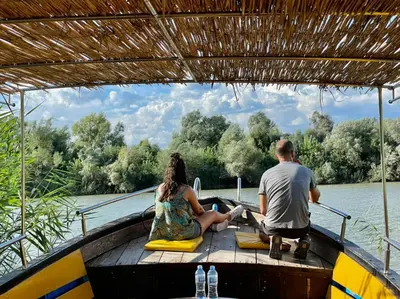 a man and woman sitting on a boat on the water at Liprosh in Virpazar