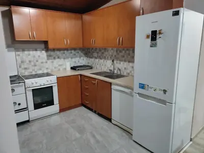 a kitchen with a white refrigerator and wooden cabinets at Liprosh in Virpazar