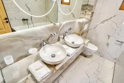 a white bathroom with a sink and a toilet at Quercus Residences Apartments in Sveti Stefan