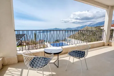 a balcony with chairs and a table and a view at Quercus Residences Apartments in Sveti Stefan