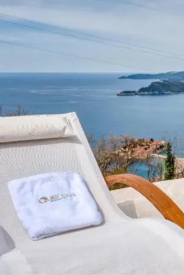 a towel sitting on a chair with a view of the ocean at Quercus Residences Apartments in Sveti Stefan