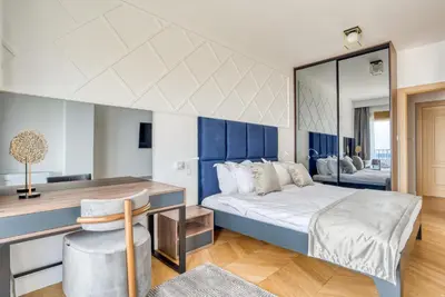 a bedroom with a bed with a desk and a mirror at Quercus Residences Apartments in Sveti Stefan