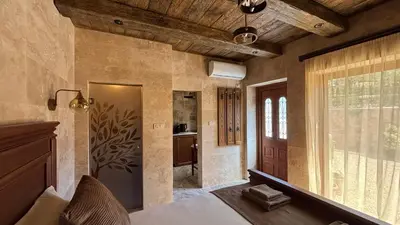a bedroom with a bed and a large window at OLIVE QUEEN Rustic Estate in Bar