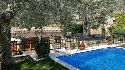 a swimming pool in a yard next to a fence at OLIVE QUEEN Rustic Estate in Bar