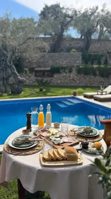 a table with plates of food and bottles of milk at OLIVE QUEEN Rustic Estate in Bar