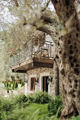 a stone house with a balcony on top of it at OLIVE QUEEN Rustic Estate in Bar