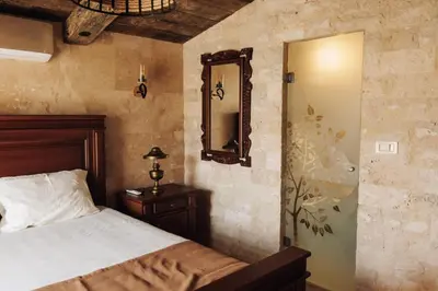 a bedroom with a bed and a mirror on the wall at OLIVE QUEEN Rustic Estate in Bar