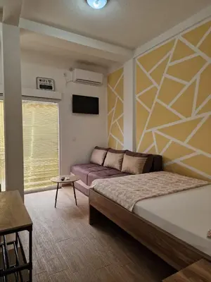 a bedroom with a bed and a couch in it at Apartment Center in Sutomore