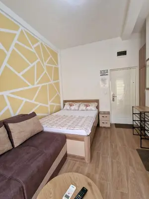 a small bedroom with a bed and a couch at Apartment Center in Sutomore