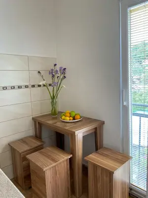 a table with a bowl of fruit and a vase of flowers at Apartment Center in Sutomore