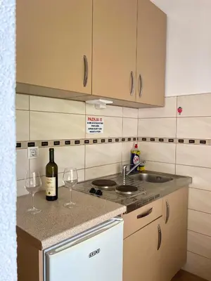 a kitchen with two wine glasses and a sink at Apartment Center in Sutomore