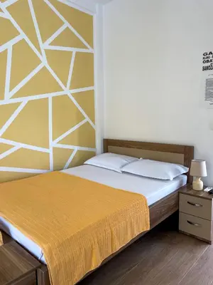 a bedroom with a bed with a yellow bedspread at Apartment Center in Sutomore