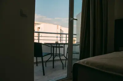a room with a balcony with a table and a chair at Apartments Casa Mia in Ulcinj
