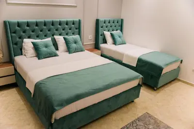 two beds with green covers in a room at Apartments Casa Mia in Ulcinj