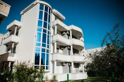 a white building with large windows at Apartments Casa Mia in Ulcinj
