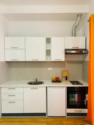 a kitchen with white cabinets and a sink at Apartment DORA in Cetinje