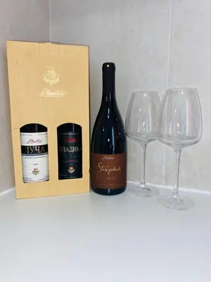 a bottle of wine next to two wine glasses at Apartment DORA in Cetinje