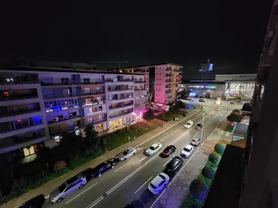 a city at night with cars parked on the street at City life in Podgorica