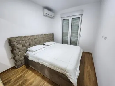 a bedroom with a large bed with white sheets at City life in Podgorica
