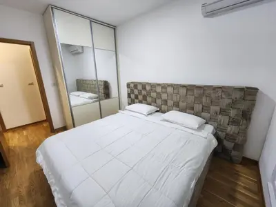 a bedroom with a large white bed and a mirror at City life in Podgorica