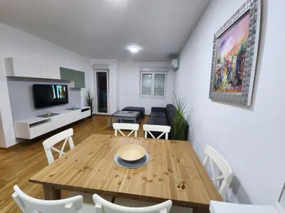 a living room with a wooden table and chairs at City life in Podgorica