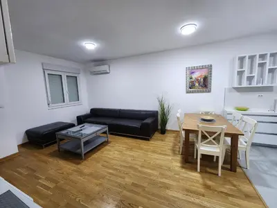 a living room with a black couch and a table at City life in Podgorica