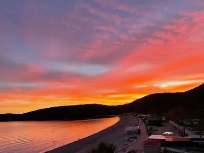 a sunset over a beach with a body of water at Beachfront Hotel Palma - Jaz in Budva