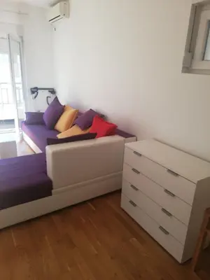 a living room with a couch and a dresser at Maša Bečići Apartman in Budva