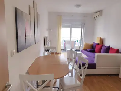 a living room with a table and a couch at Maša Bečići Apartman in Budva