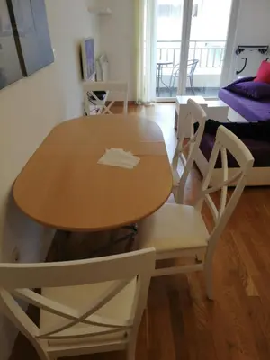 a wooden table and chairs in a living room at Maša Bečići Apartman in Budva