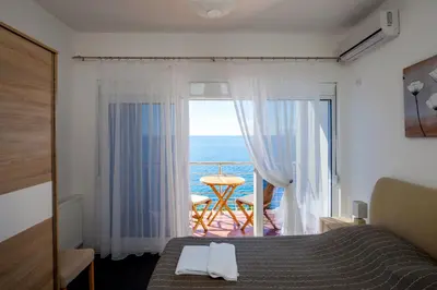 a bedroom with a bed and a view of the ocean at Royal Villas in Dobra Voda