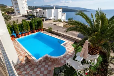 a swimming pool on the balcony of a house with the ocean at Royal Villas in Dobra Voda