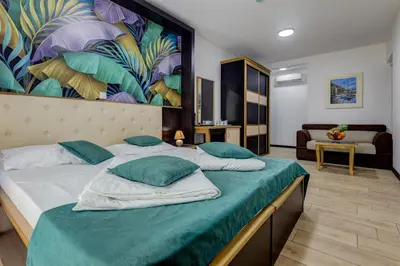 a bedroom with a bed with a large painting on the wall at Porta Volta Residence in Becici