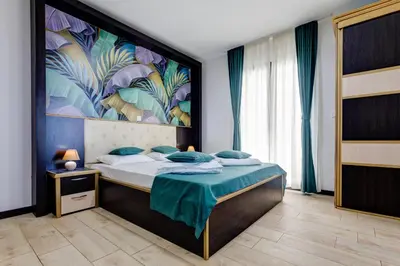 a bedroom with a bed with a painting on the wall at Porta Volta Residence in Becici