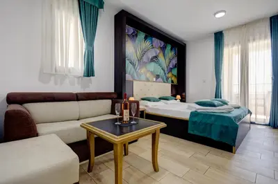a living room with a couch and a bed at Porta Volta Residence in Becici