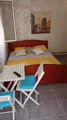 a bed with a table and two chairs in a room at Two in Petrovac na Moru