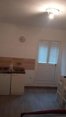 a kitchen with a door and a clock on the wall at Two in Petrovac na Moru