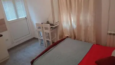 a bedroom with a bed and a window and a ladder at Two in Petrovac na Moru
