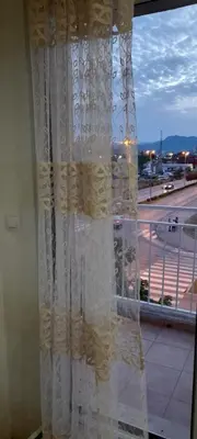 a curtain on a window with a view of a street at Apartment Luka in Podgorica