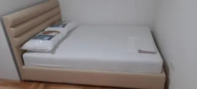 a bed in a room with a white mattress at Apartment Luka in Podgorica