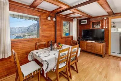 a dining room with a table and a television at Vukićević House in Kotor