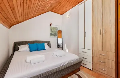 a bedroom with a bed and a wooden ceiling at Vukićević House in Kotor