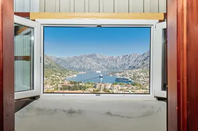 a window with a view of a city and water at Vukićević House in Kotor