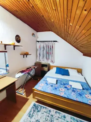 a bedroom with a bed with a wooden ceiling at Vukićević House in Kotor