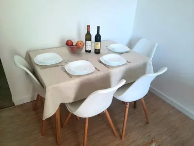a table with white chairs and bottles of wine at Acacia apartmani Sutomore in Sutomore