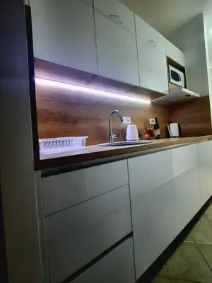 a kitchen with white cabinets and a sink at Acacia apartmani Sutomore in Sutomore